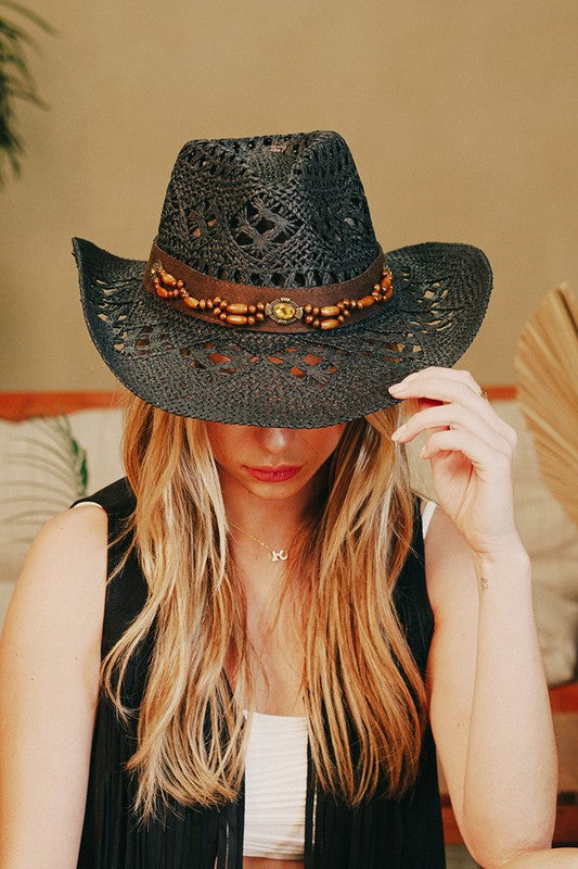 Featuring a a woven cowboy style hat with a beaded belt detail in the color black 