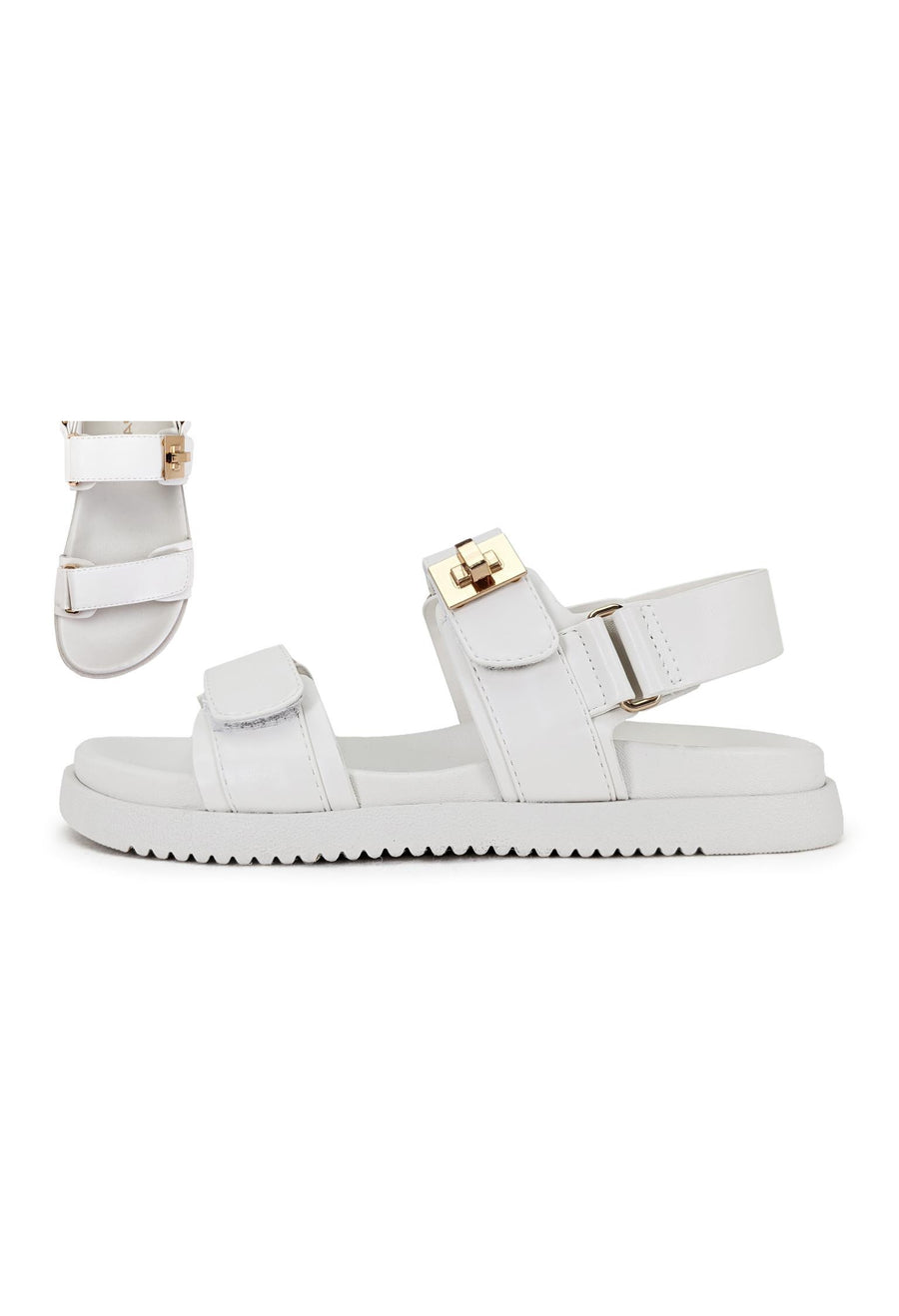 Featuring an open toed double strap sandle with buckle detail across the strap in the color bone 