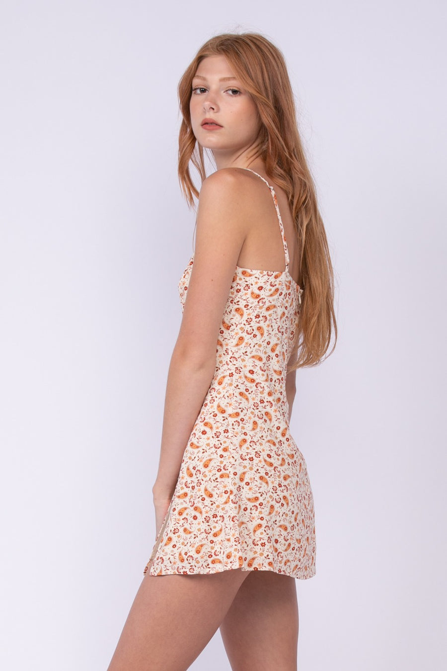 Model is wearing a floral print mini dress with side slit.