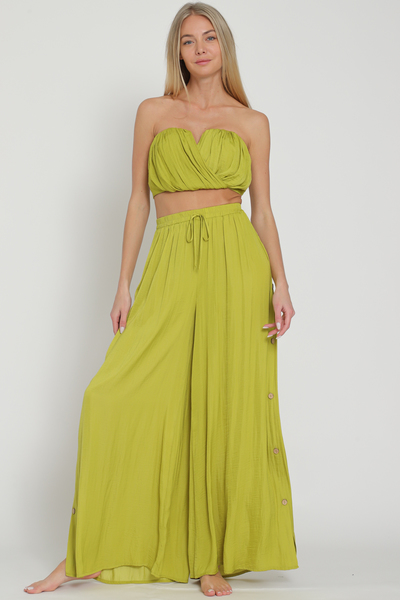 Featuring flowy long pants with buttons up both sides, an elastic waist and drawstring detail in the color Lime Green.
