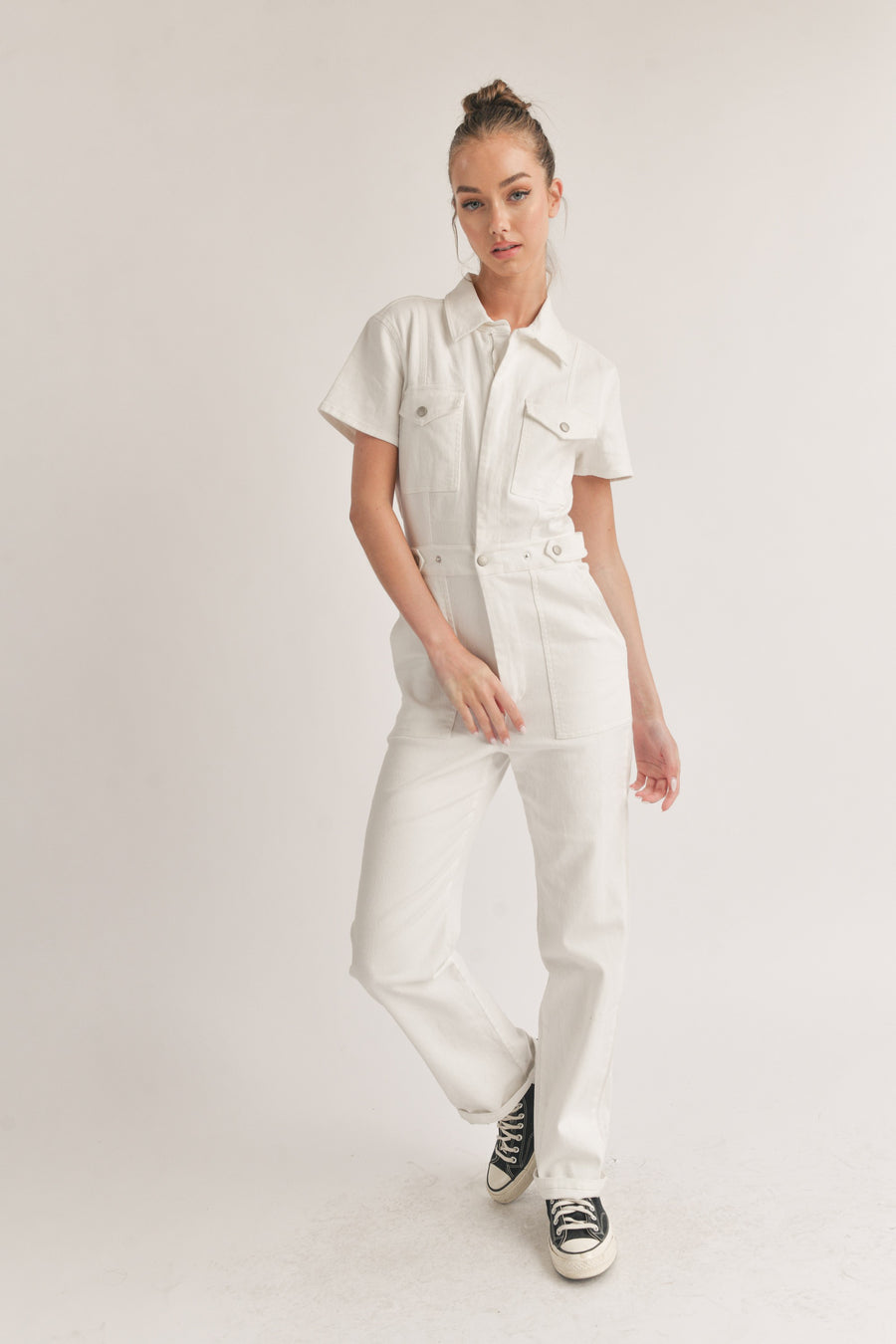 Featuring a short sleeve zip up jumpsuit in the color ivory 