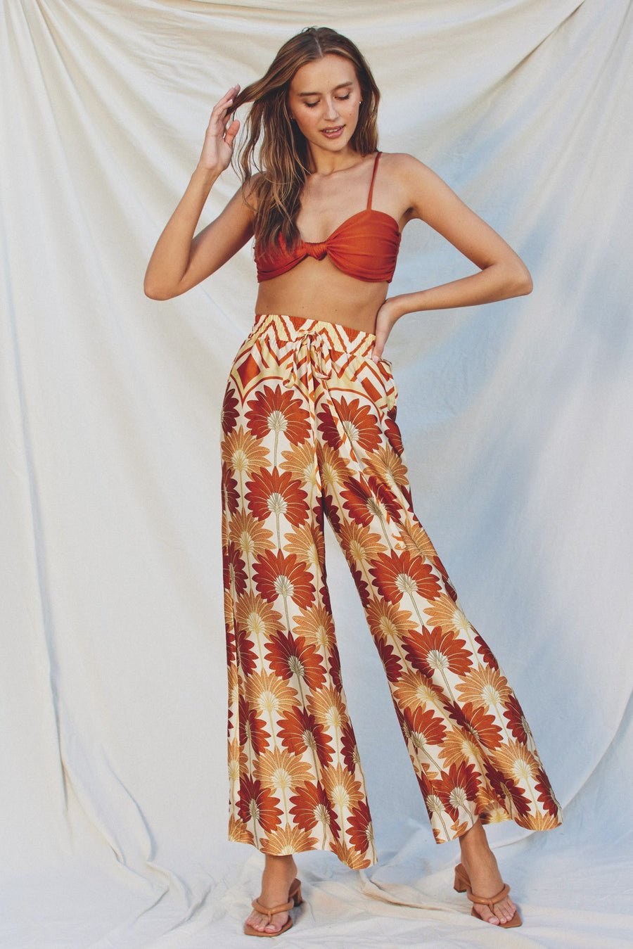 Featuring a loose fit high waisted pant with an elastic waist band and a front tie n the color and print hawaiian sunset 