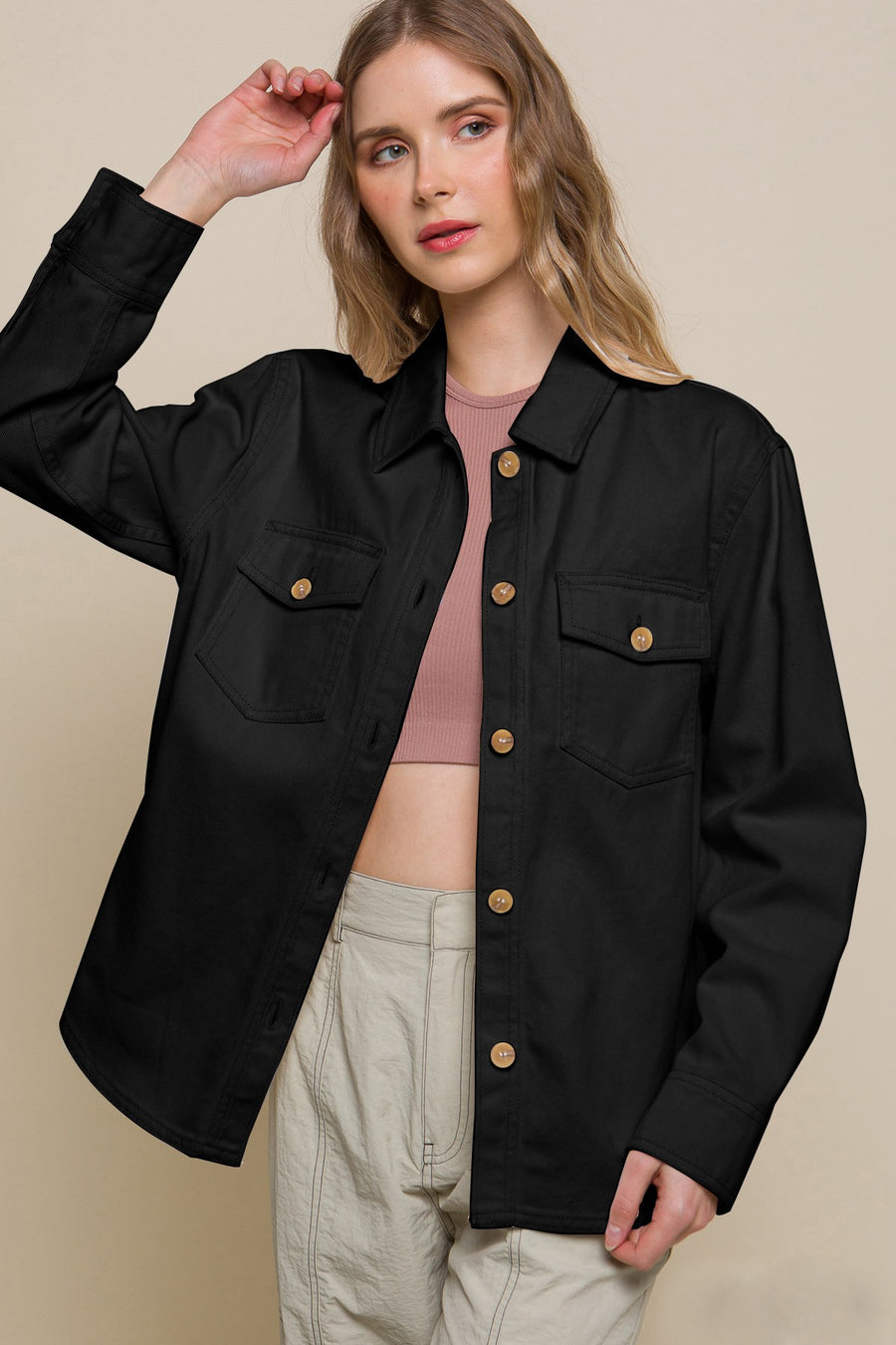 Featuring a longsleeve button up jacket with two front pockets in the color black