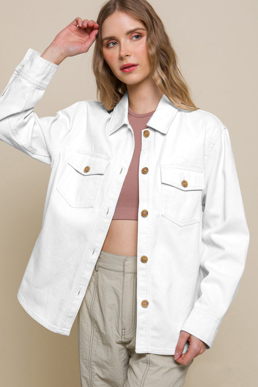 Featuring a longsleeve button up jacket with two front pockets in the color white 