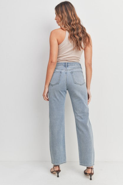 High-waisted, non-stretch denim pants with rips on the knees.