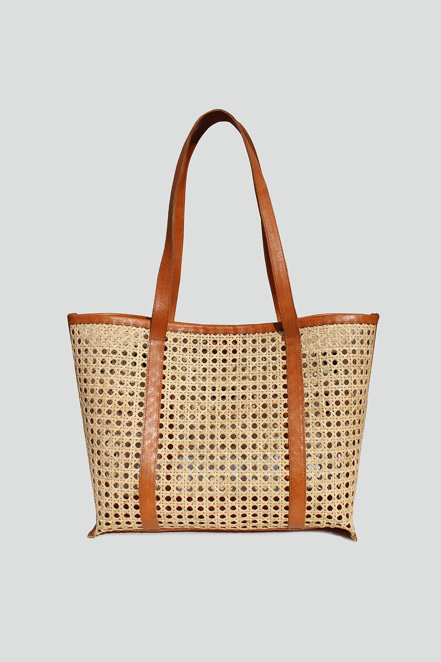 Featuring a large rattan detailed shoulder bag with a magnetic snap closure in the color tan