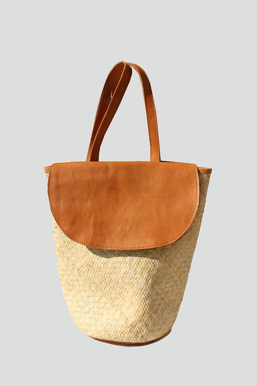 Featuring a snap closure wicker detailed backpack in the color tan