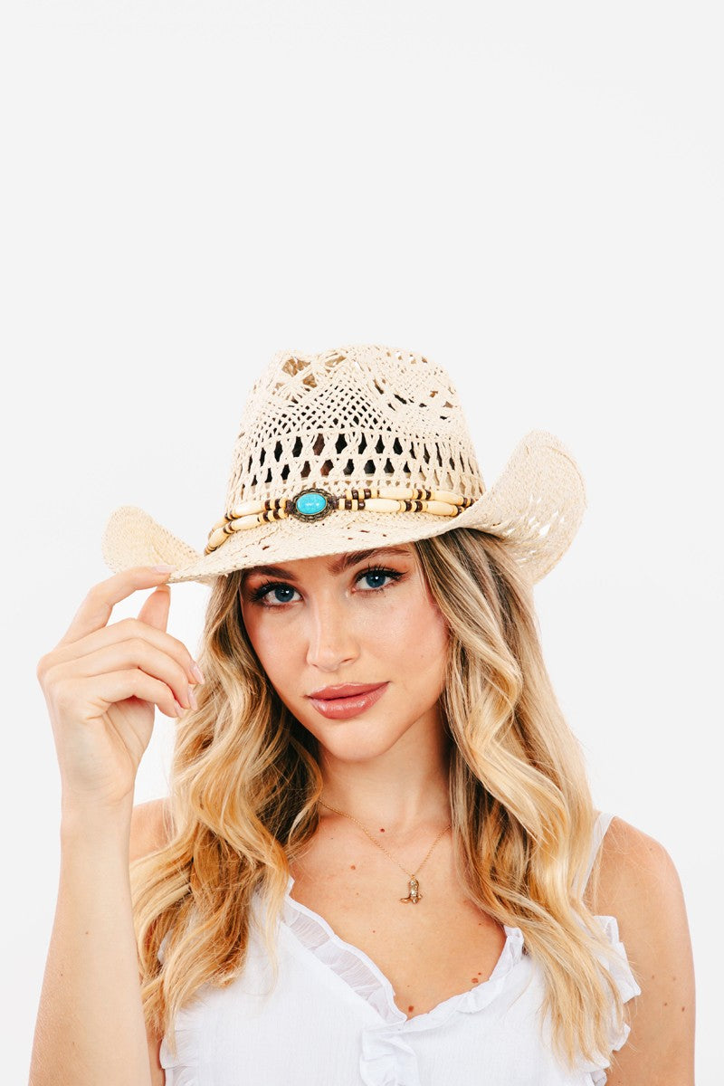 Featuring a straw hat with a curved brim with decorative strap detail in the color ivory 