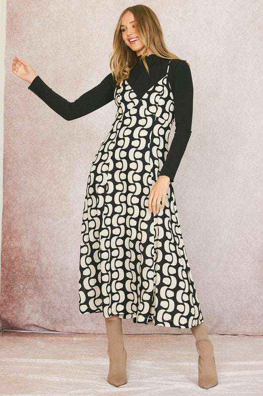 Featuring a spaghetti strap abstract print midi dress with pockets on each side and an open back with a tie detail in the color black and white 