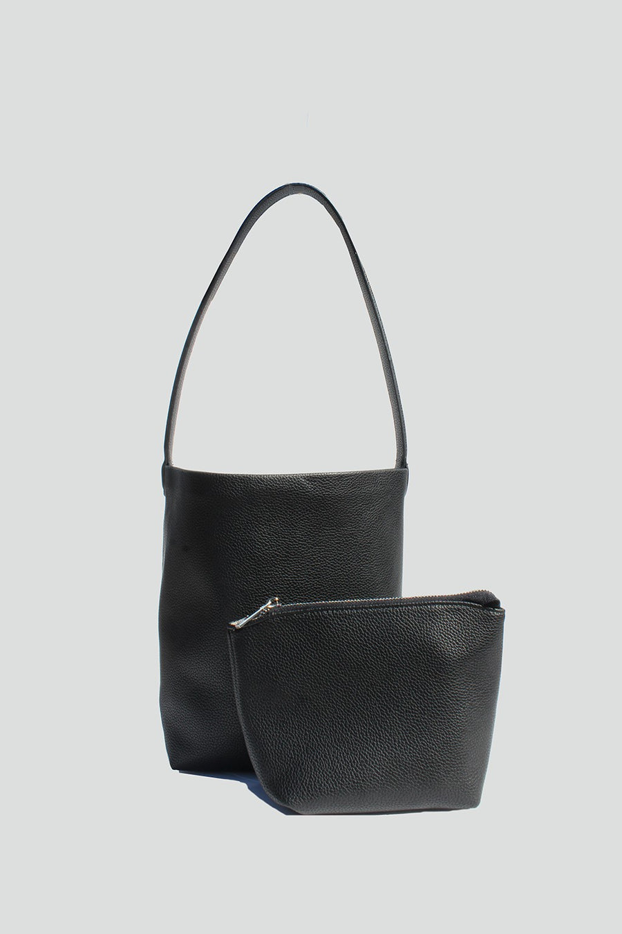 Featuring a classic tote style bag with magnetic closure and includes a mini pouch in the color black 