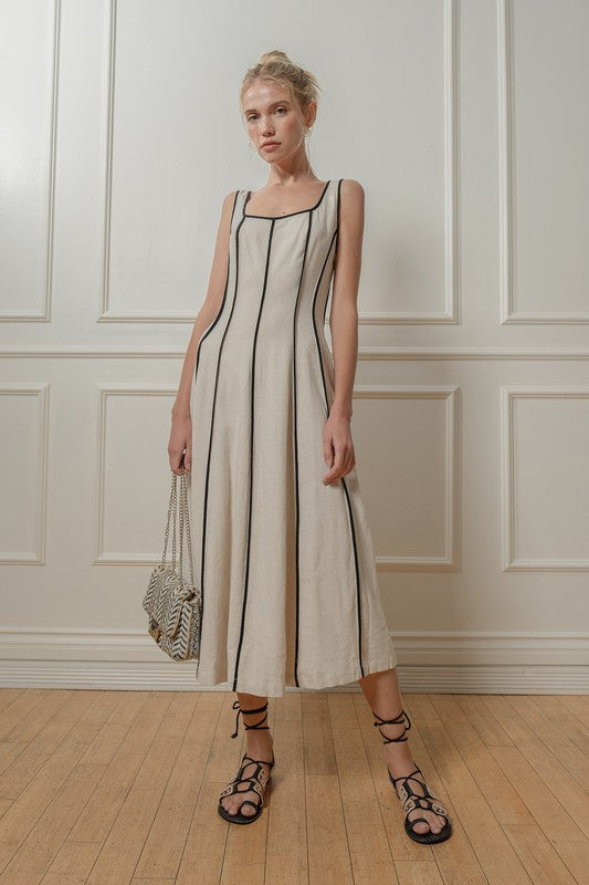 Featuring a square neck midi dress with side zip closure and bind detailing in the color natural and black 