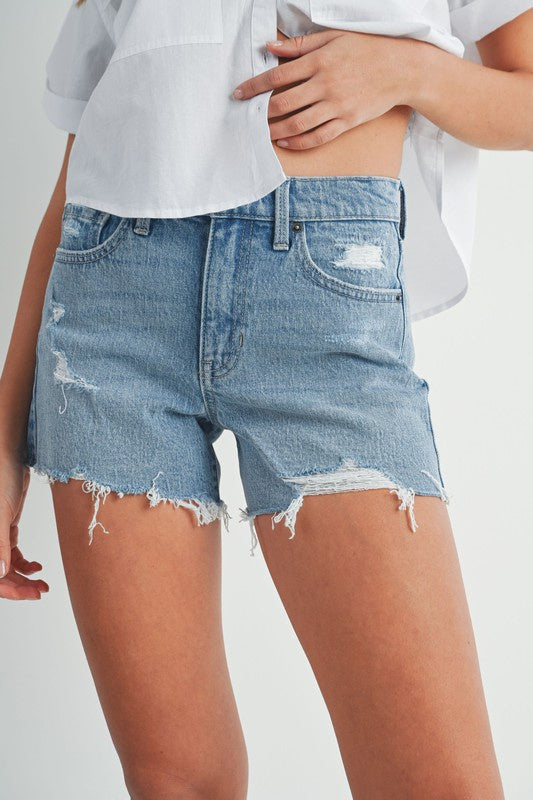 Featuring a mid rise light wash denim distressed short in the color washed blue 