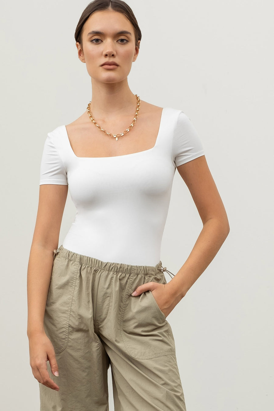 Featuring a square neck short sleeve bodysuit in the color white