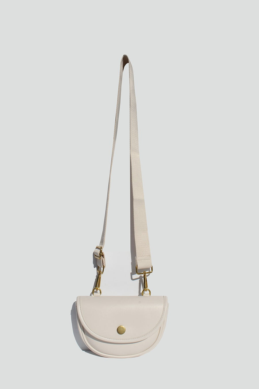 Featuring a small multi compartment crossbody bag with an adjustable strap in the color ivory 