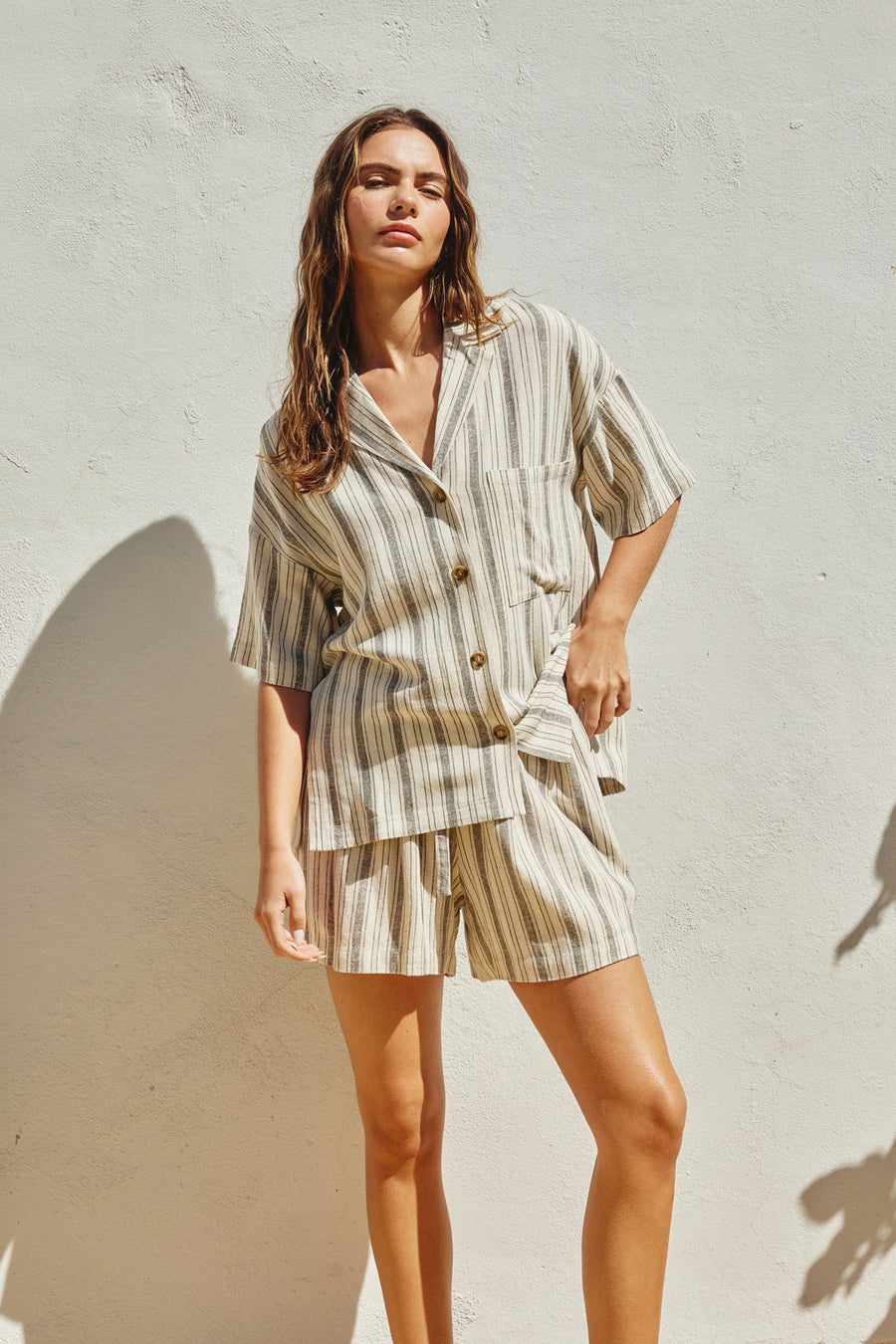 Featuring a stripped button down short sleeve top with matching draw string shorts