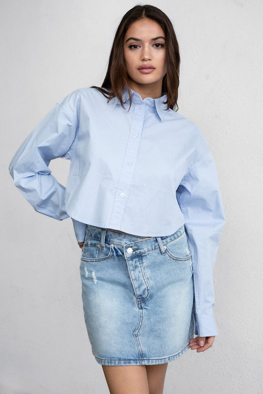 Featuring a long sleeve cropped button up in the color pastel blue