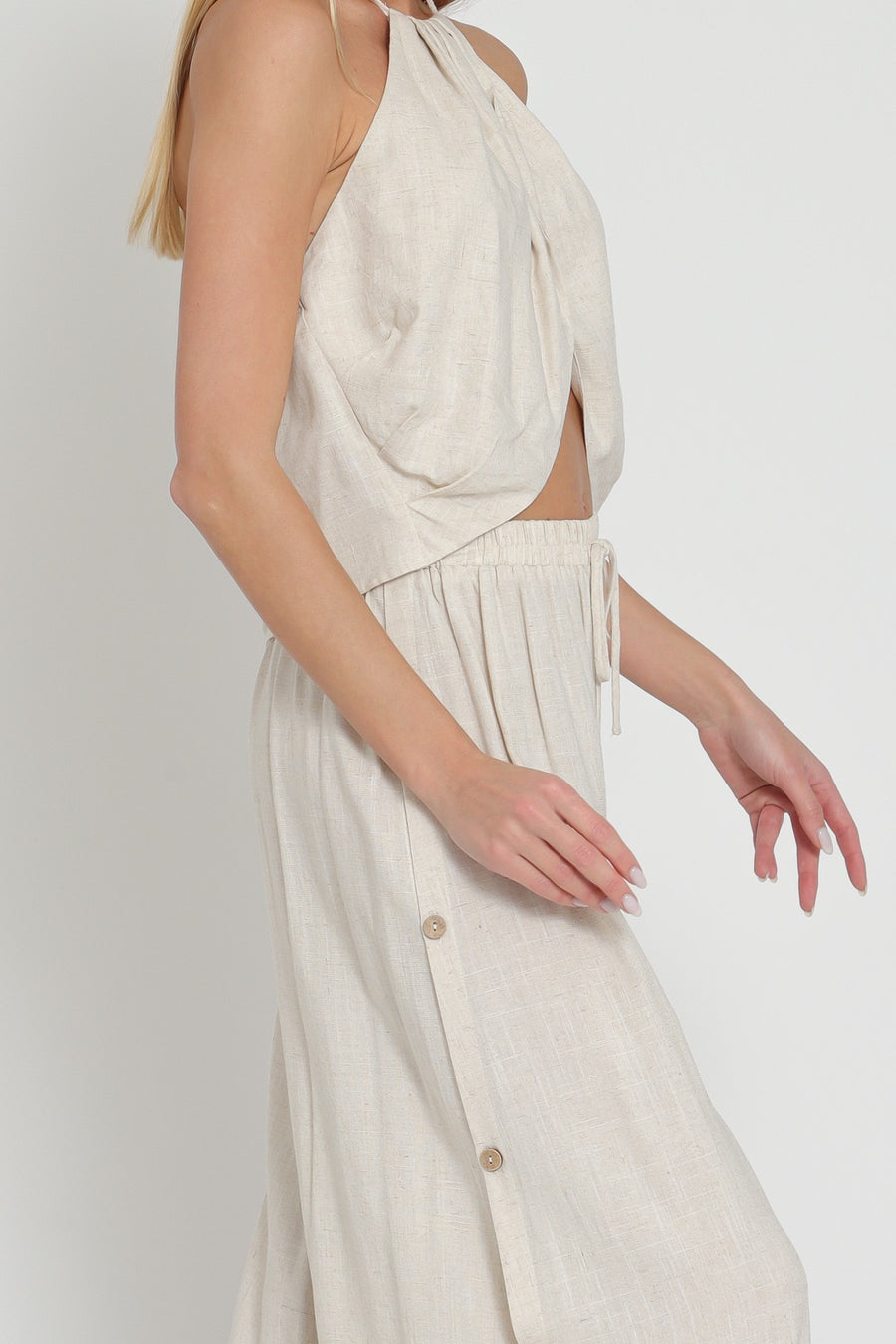 Pairs with the matching Ephie Wide Leg Pant  Featuring a cross over halter top in the color oatmeal