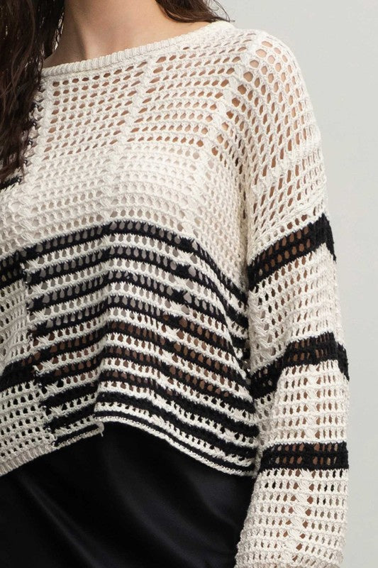 Featuring a wide knit contrast stripe sweater in the color black and white 