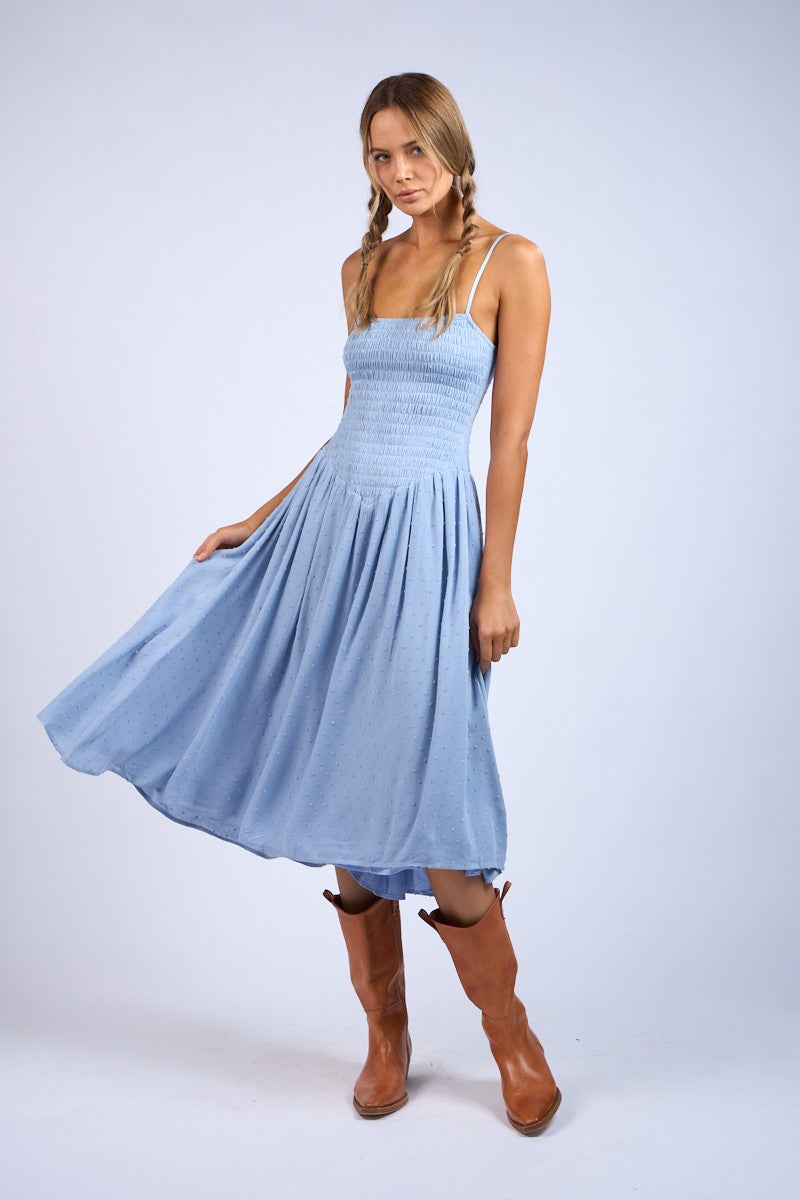 Featuring a smocked body clip dot midi dress with adjustable spaghetti straps in the color baby blue 