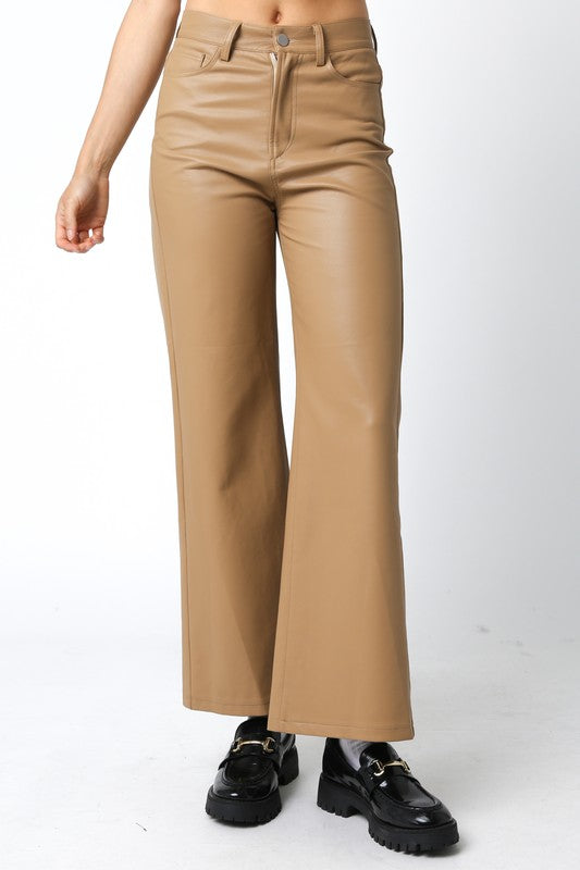 Featuring a wide leg faux leather full lenght pant with a button for closure in the color tan