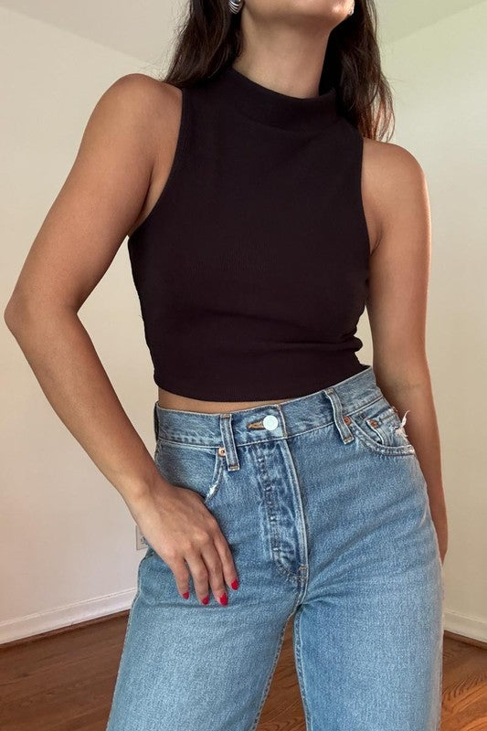 Featuring a cropped sleeveless mock neck top in the color black 