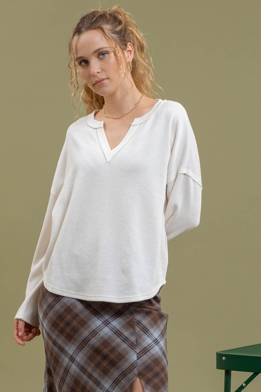 Featuring a knit V-neck long sleeve top in the color cream 