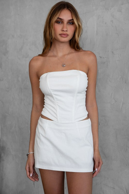 Featuring a mini skirt with a side zip closure in the color white 