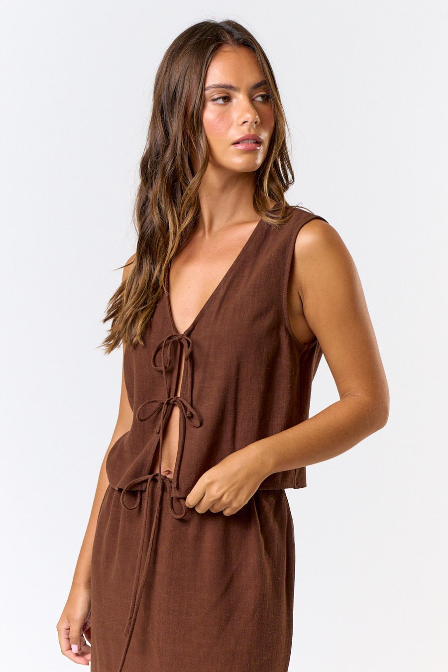 Featuring a linen, sleeveless front tie top in the color brown 