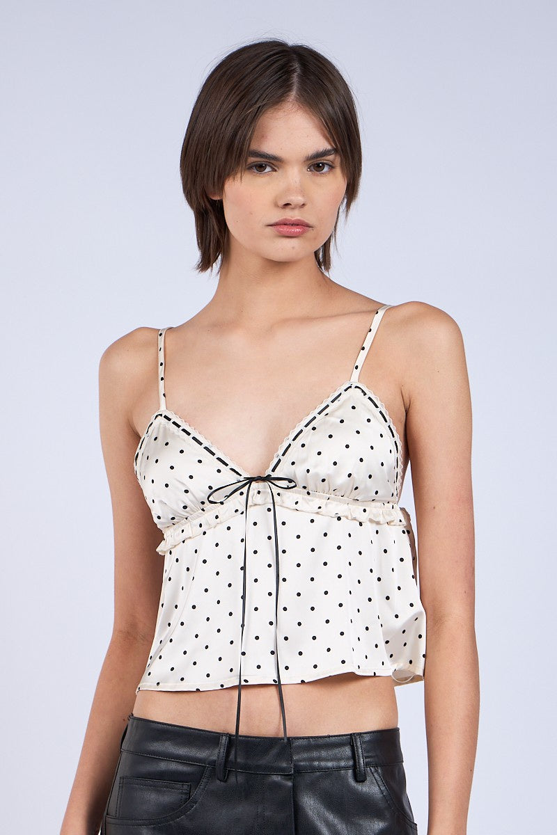 Featuring a black and white print cami crop top with a ruffle trim and a front tie.