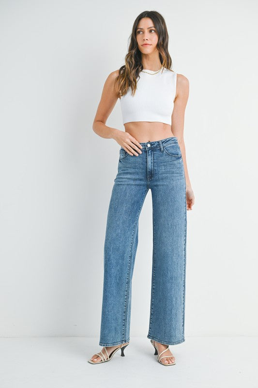 Featuring a stretchy mid waist wide leg jeans in the color dark denim