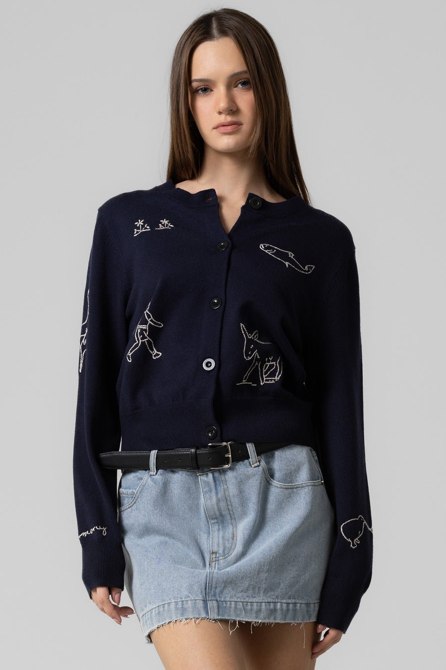 Featuring a button up cardigan with embroidered details throughout in the color navy 