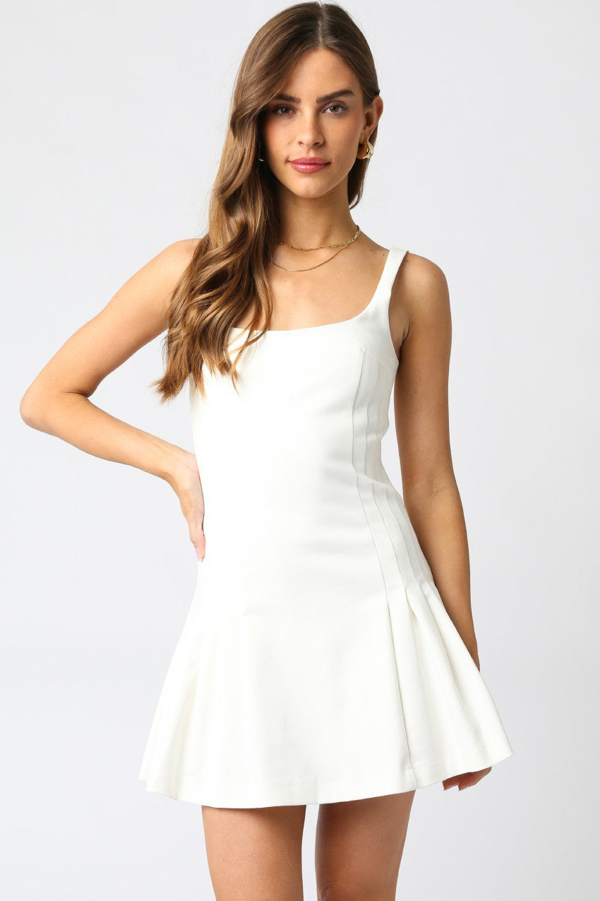 Featuring a white baby doll mini dress with a flounce hem and open back