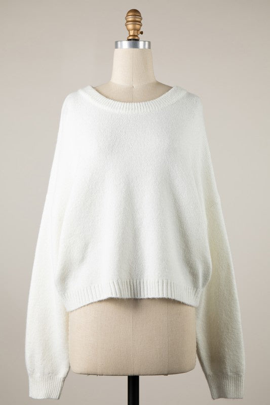 Featuring a long sleeve cropped ribbed sweater. 