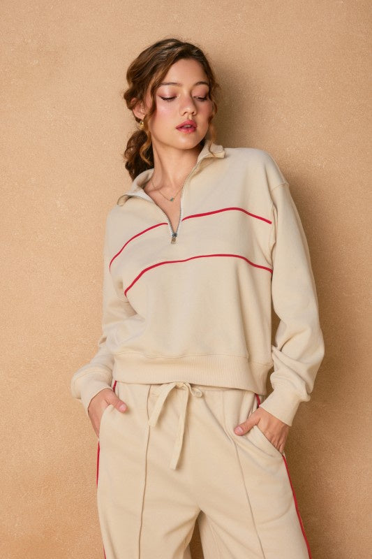 Featuring a collared french terry sweatshirt with a half zipper and binding detail
