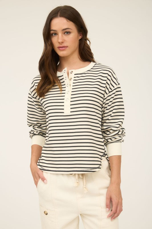 Featuring a stripe henley long sleeve knit top with snap button