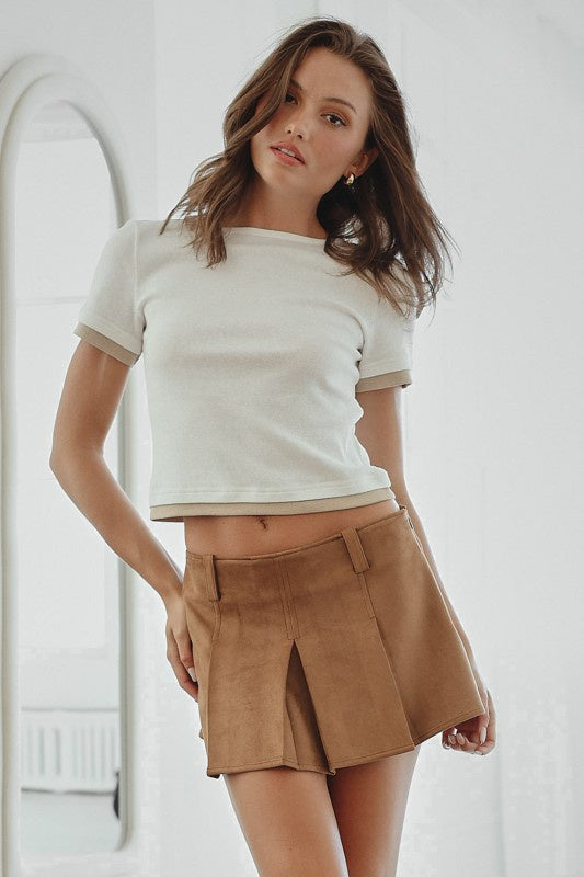 Featuring a white cropped tee that is double layered with a taupe/tan tee underneath 