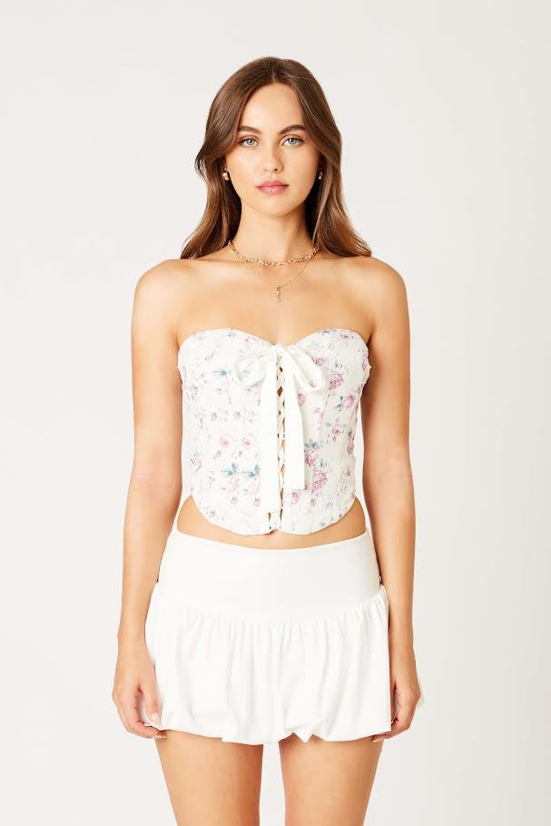 Featuring a floral stapless lace up corset top in the color ivory rose 