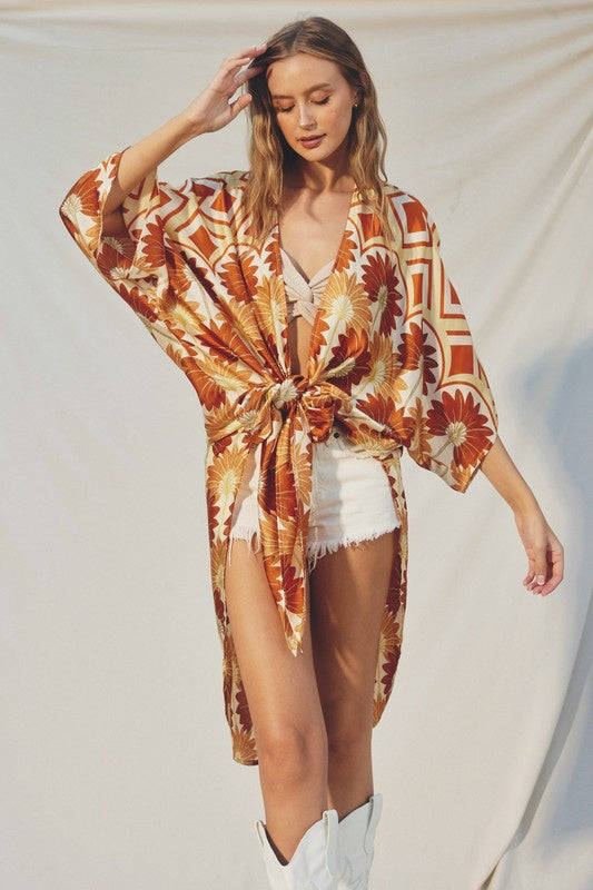 Featuring a silky quarter sleeve kimono with side slits and a front tie in the print and color hawaiian sunset 