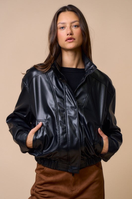 Featuring a black leather bomber jacket with side pockets, zipper and button closure