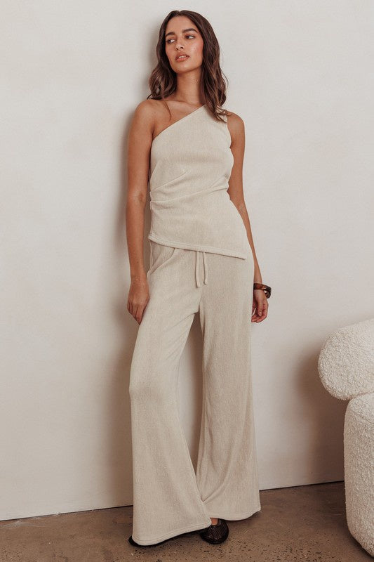 Pairs with the matching Sirius Loose Fit Pant

Featuring a one shoulder asymmetryical top in the color oat 