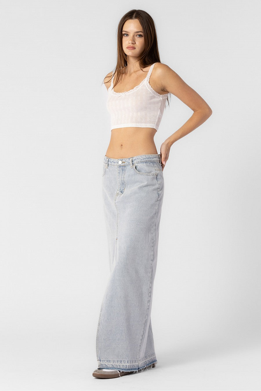 Model is wearing a maxi denim skirt with front slit.