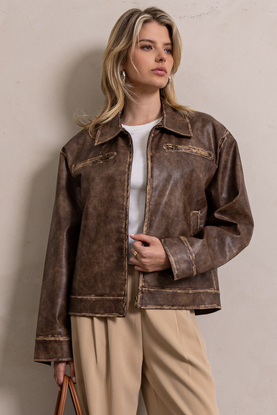 Featuring a brown leather jacket with top zipper pockets and side pockets