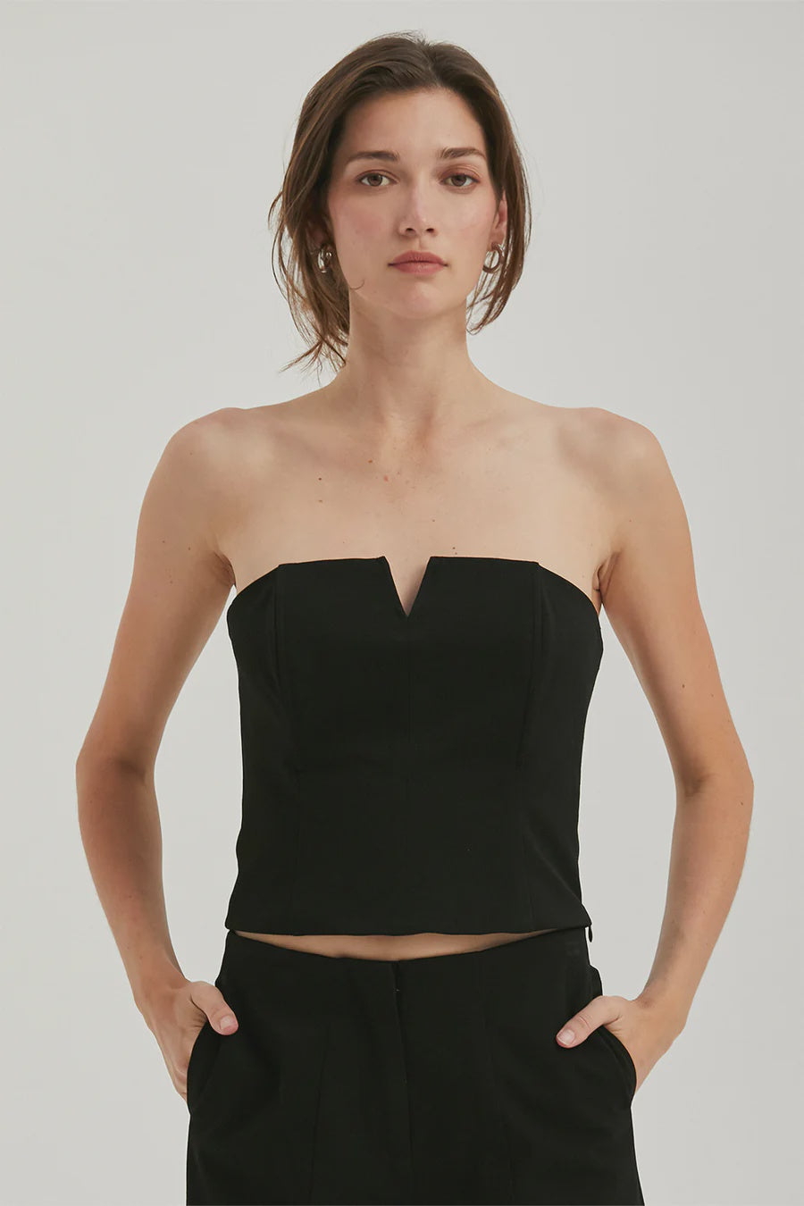 Featuring a tube top with a V-wire and a hidden zipper detail in the color black 