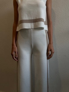 Featuring a white, stretchy and soft material pant with beige detailing on the sides, with a matching top.