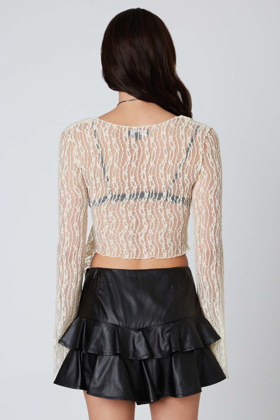 Sheer lace cropped top with plunging neckline and bell sleeves.