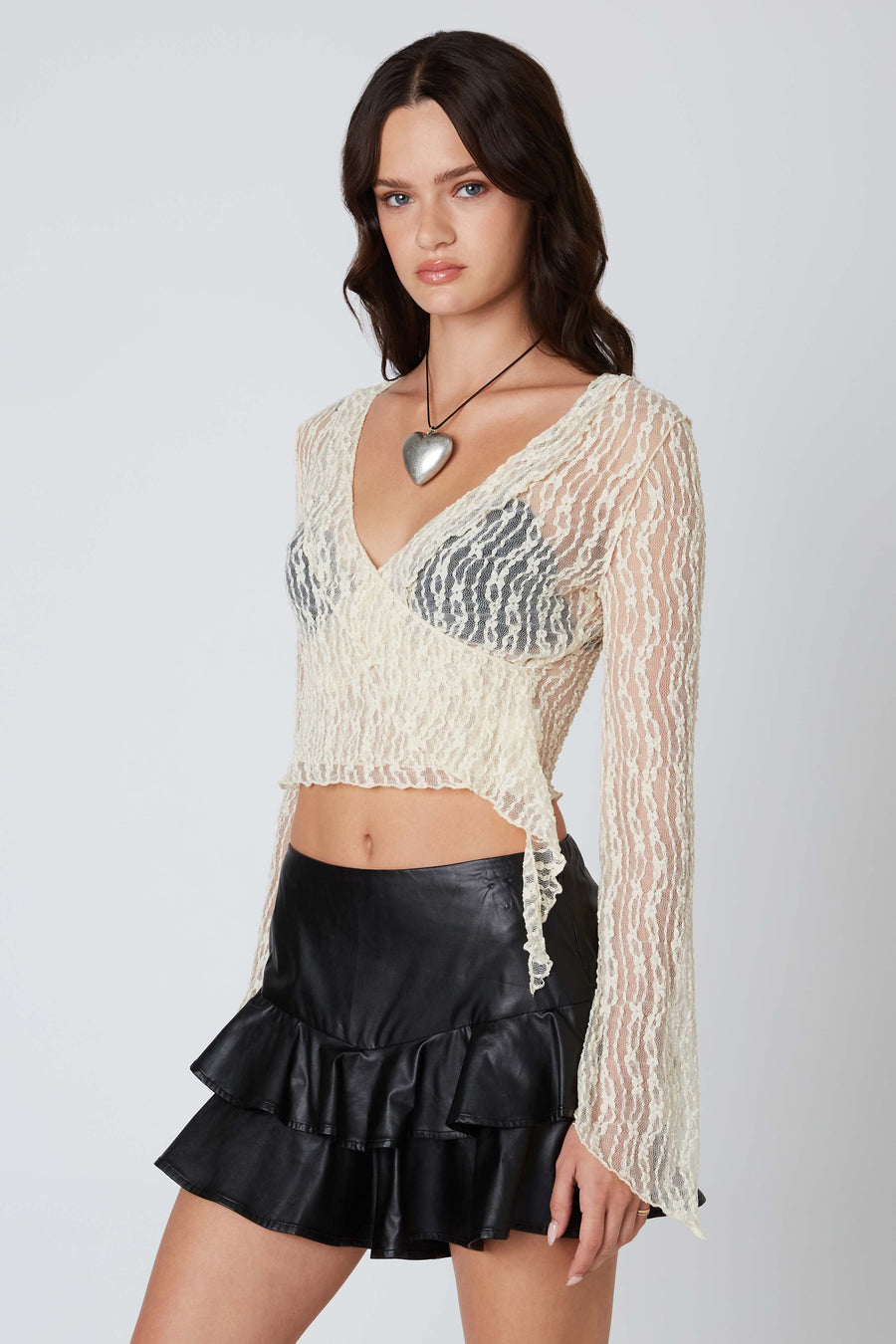 Sheer lace cropped top with plunging neckline and bell sleeves.