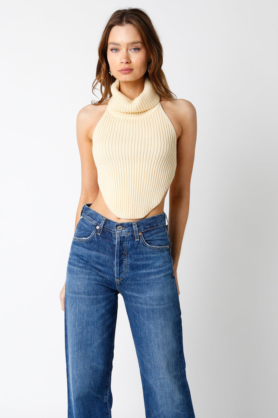 Cream turtle neck sleeveless top with open back. 