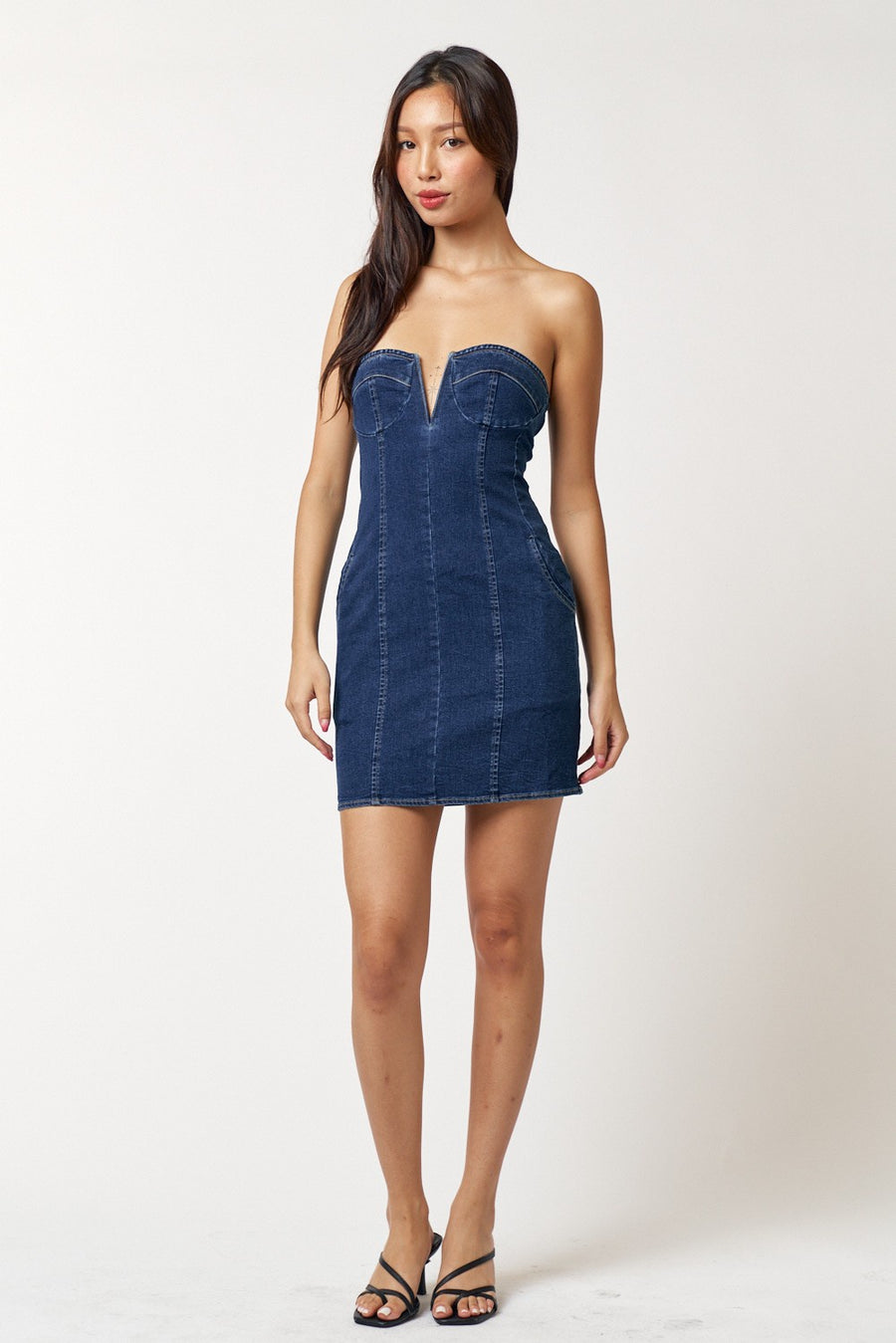 Featuring a strapless denim mini dress with a V-cut and pockets on each side In the shade dark denim 