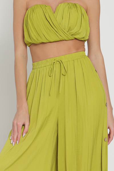 Featuring a strapless crop top with a V Neckline and draping detailing in the color Lime Green.