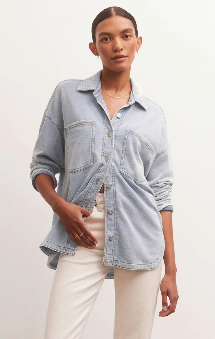 Denim jacket with a long hem and curved hem. Two front pockets and button closure in the front.